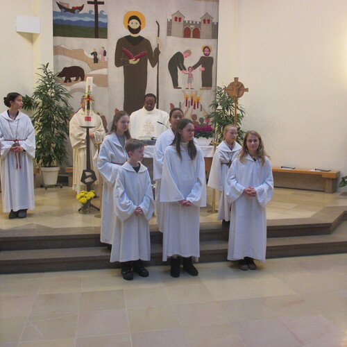 Drei junge Menschen, die sich in den Dienst mit den übrigen Ministrantinnen stellen, bringen Dynamik und Wertschätzung in die liturgischen Feierlichkeiten ein