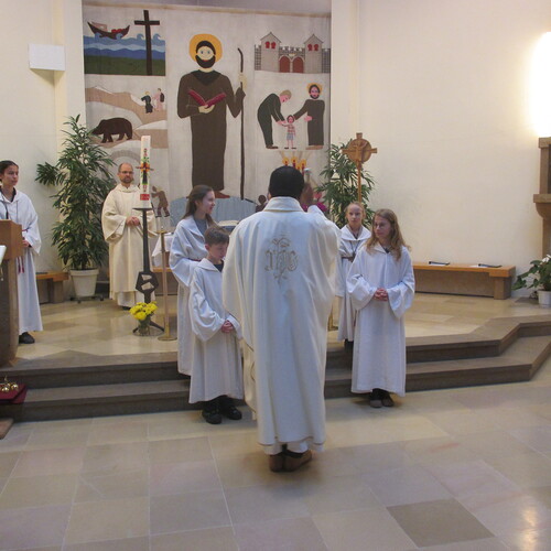 Drei junge Menschen, die sich in den Dienst mit den übrigen Ministrantinnen stellen, bringen Dynamik und Wertschätzung in die liturgischen Feierlichkeiten ein