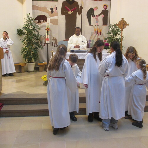 Drei junge Menschen, die sich in den Dienst mit den übrigen Ministrantinnen stellen, bringen Dynamik und Wertschätzung in die liturgischen Feierlichkeiten ein