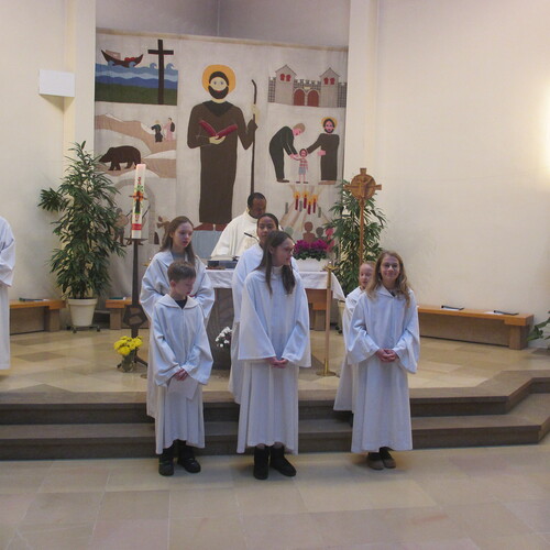 Drei junge Menschen, die sich in den Dienst mit den übrigen Ministrantinnen stellen, bringen Dynamik und Wertschätzung in die liturgischen Feierlichkeiten ein