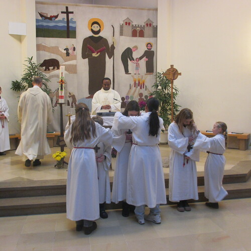 Drei junge Menschen, die sich in den Dienst mit den übrigen Ministrantinnen stellen, bringen Dynamik und Wertschätzung in die liturgischen Feierlichkeiten ein